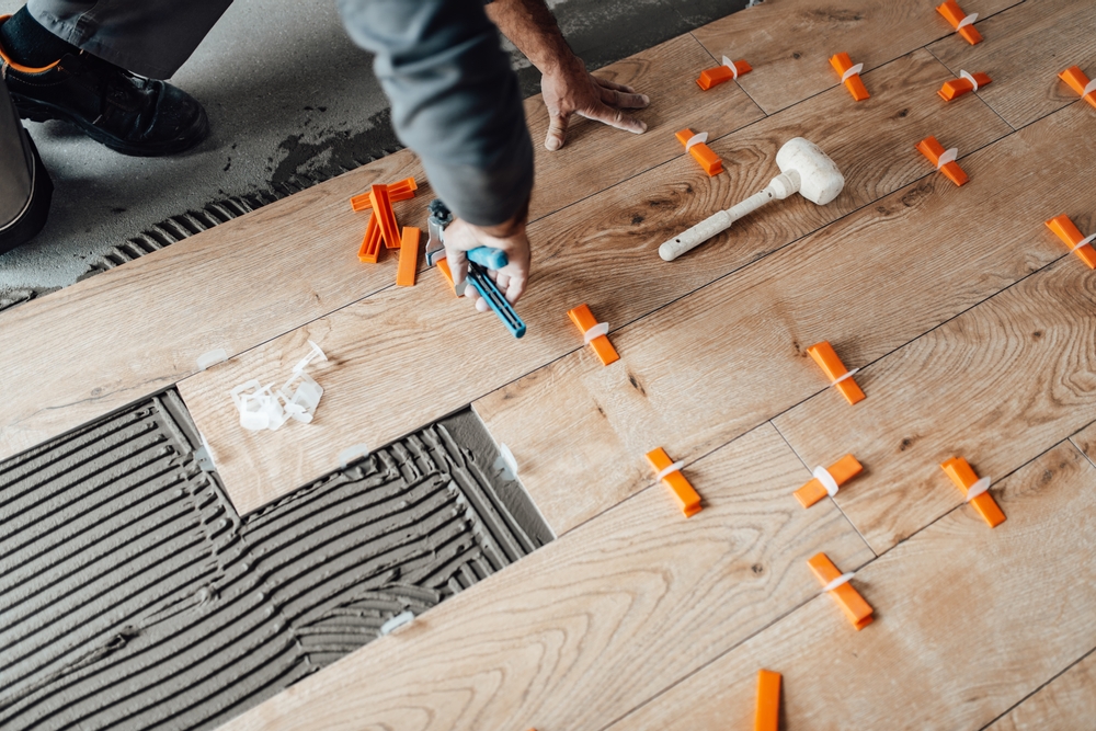 Professional,Tiler,Placing,Level,In,Position,With,Lash,Tile,Leveling